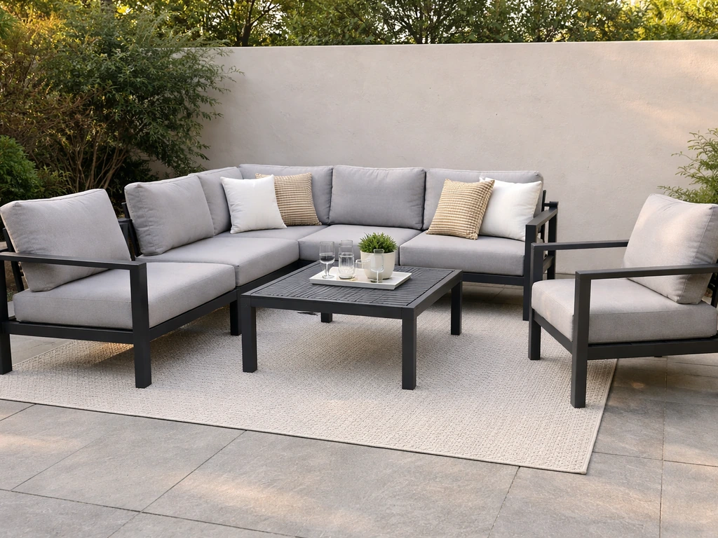 Outdoor patio conversation set with sectional, two armchairs, and coffee table in natural light.