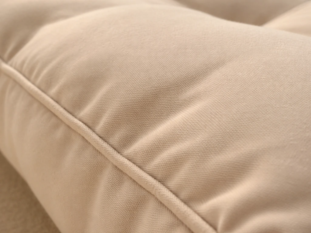 Macro view of a beige cushion cover showing water-repellent fabric texture and foam padding contours.